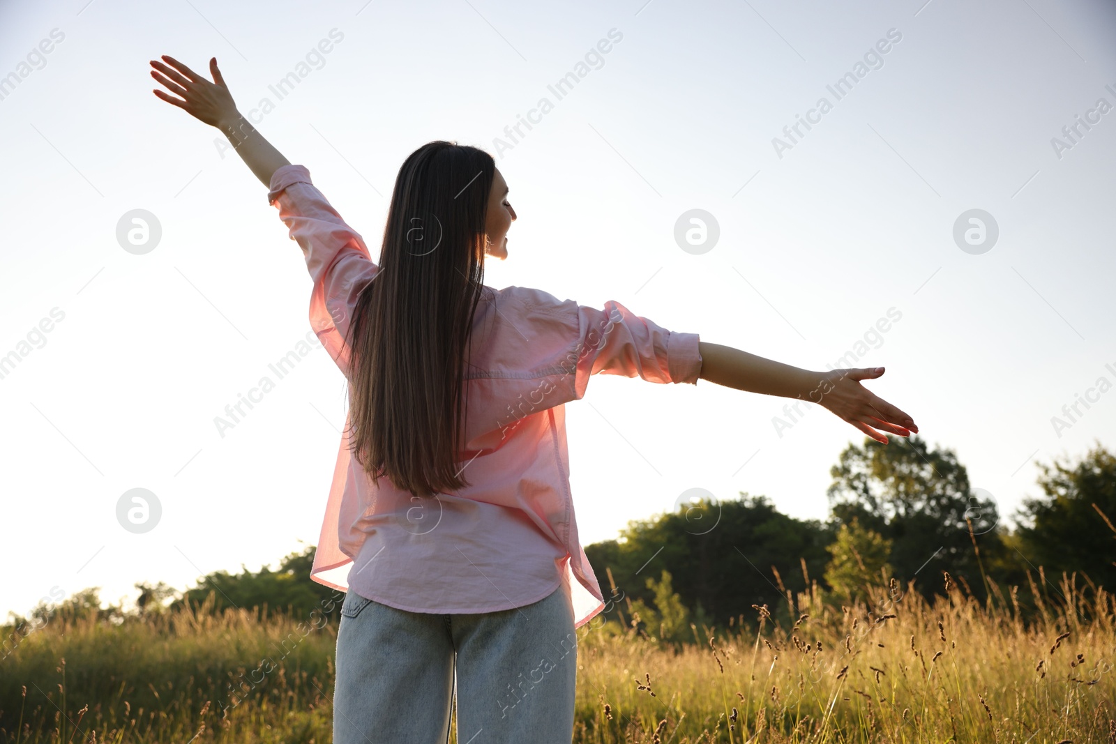 Photo of Feeling freedom. Happy young woman enjoying time in nature, low angle view