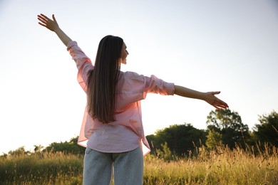 Photo of Feeling freedom. Happy young woman enjoying time in nature, low angle view