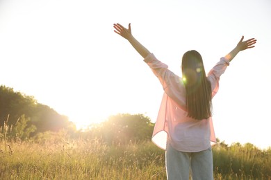 Photo of Feeling freedom. Woman enjoying time in nature, back view. Space for text