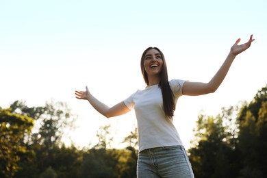 Photo of Feeling freedom. Happy young woman enjoying time in nature, low angle view