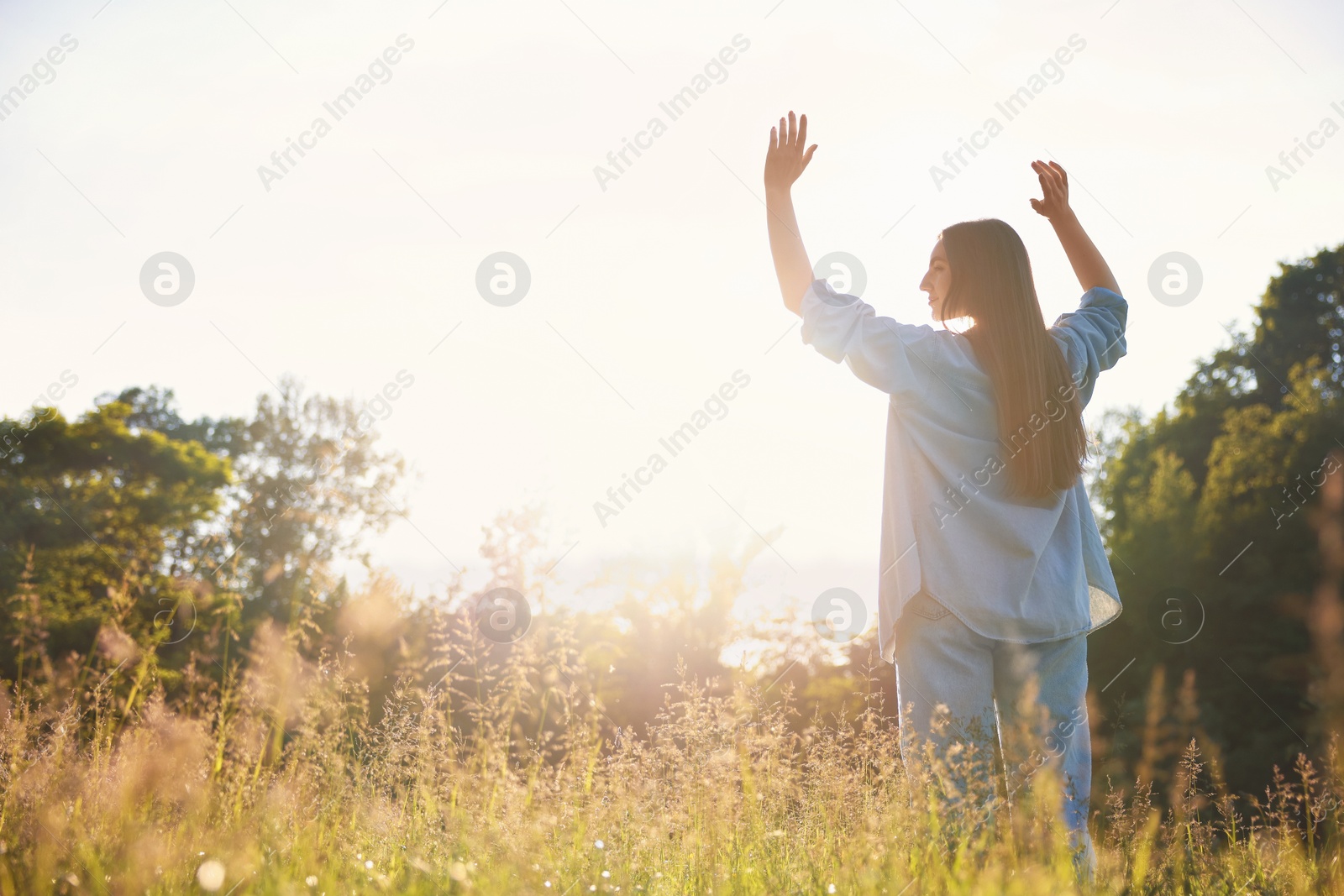 Photo of Feeling freedom. Woman enjoying time in nature on sunny day, low angle view. Space for text
