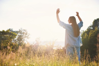 Photo of Feeling freedom. Woman enjoying time in nature on sunny day, low angle view. Space for text