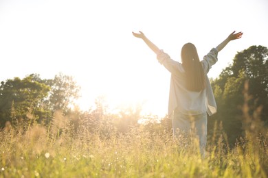 Photo of Feeling freedom. Woman enjoying time in nature on sunny day, low angle view. Space for text