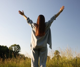 Photo of Feeling freedom. Woman enjoying time in nature, back view