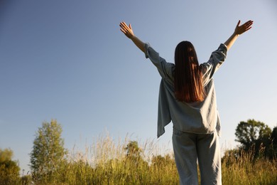 Photo of Feeling freedom. Woman enjoying time in nature, back view. Space for text
