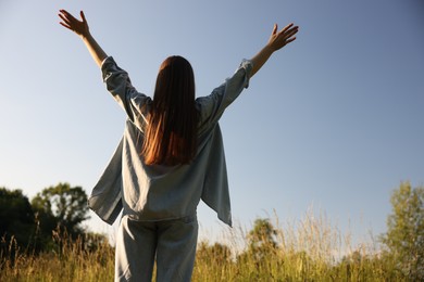Photo of Feeling freedom. Woman enjoying time in nature, back view
