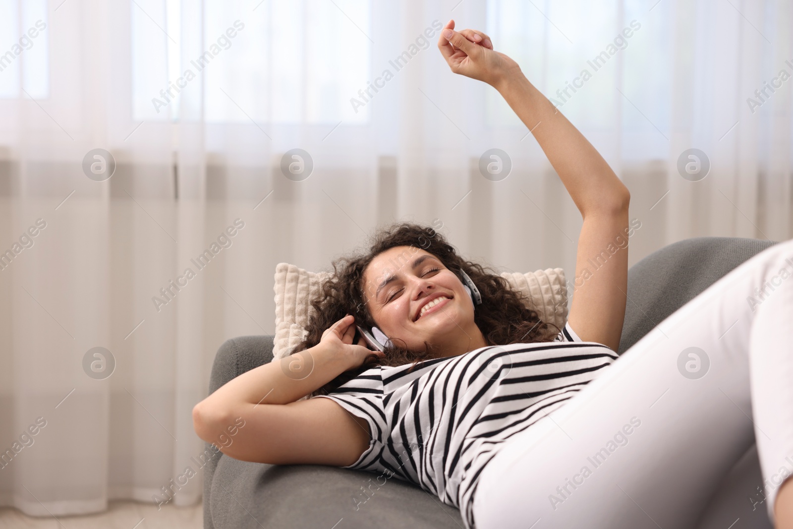 Photo of Young woman with headphones listening to music at home