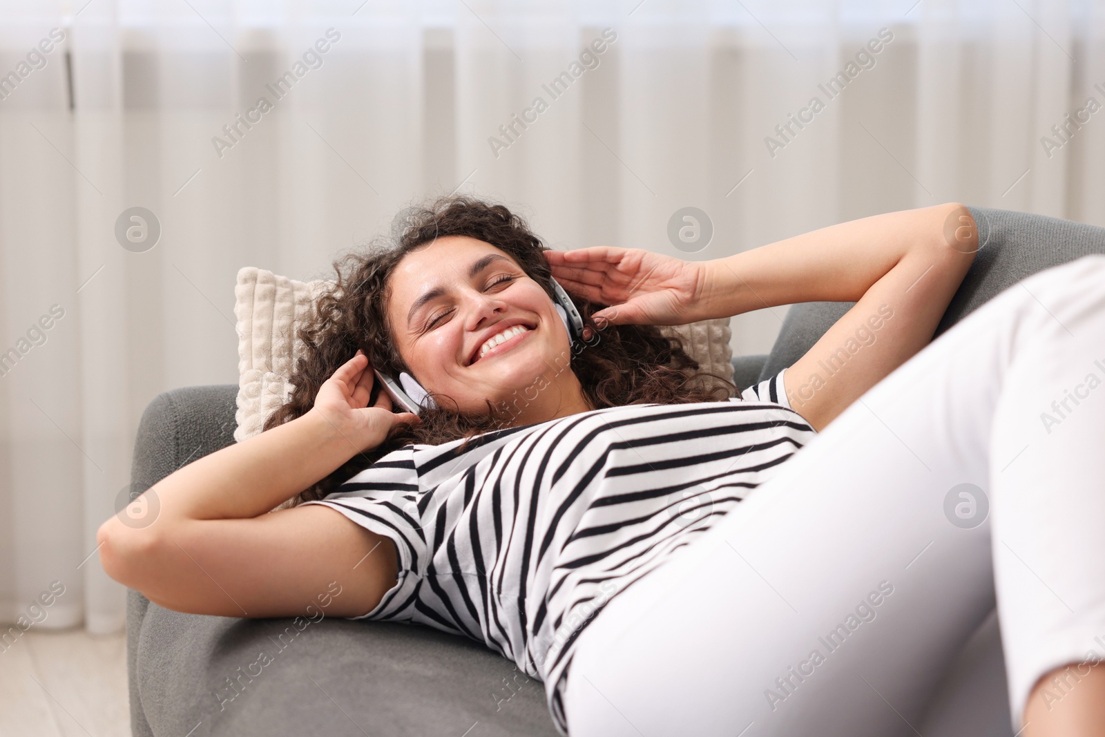 Photo of Young woman with headphones listening to music at home
