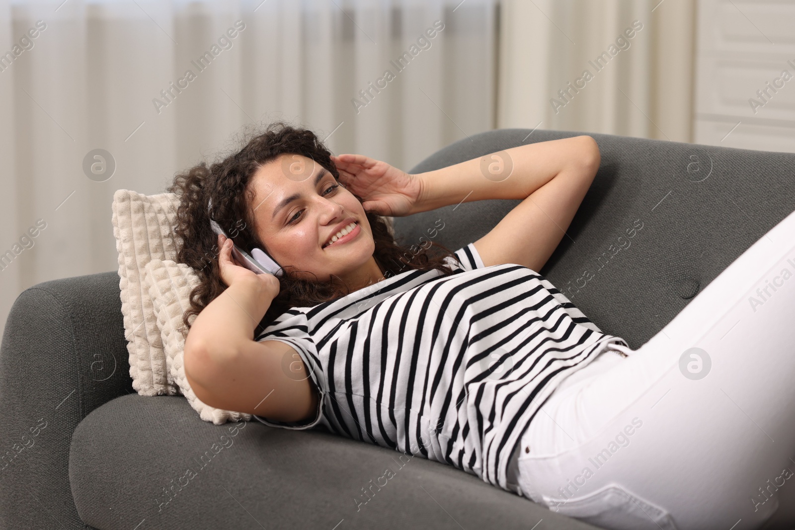Photo of Young woman with headphones listening to music at home