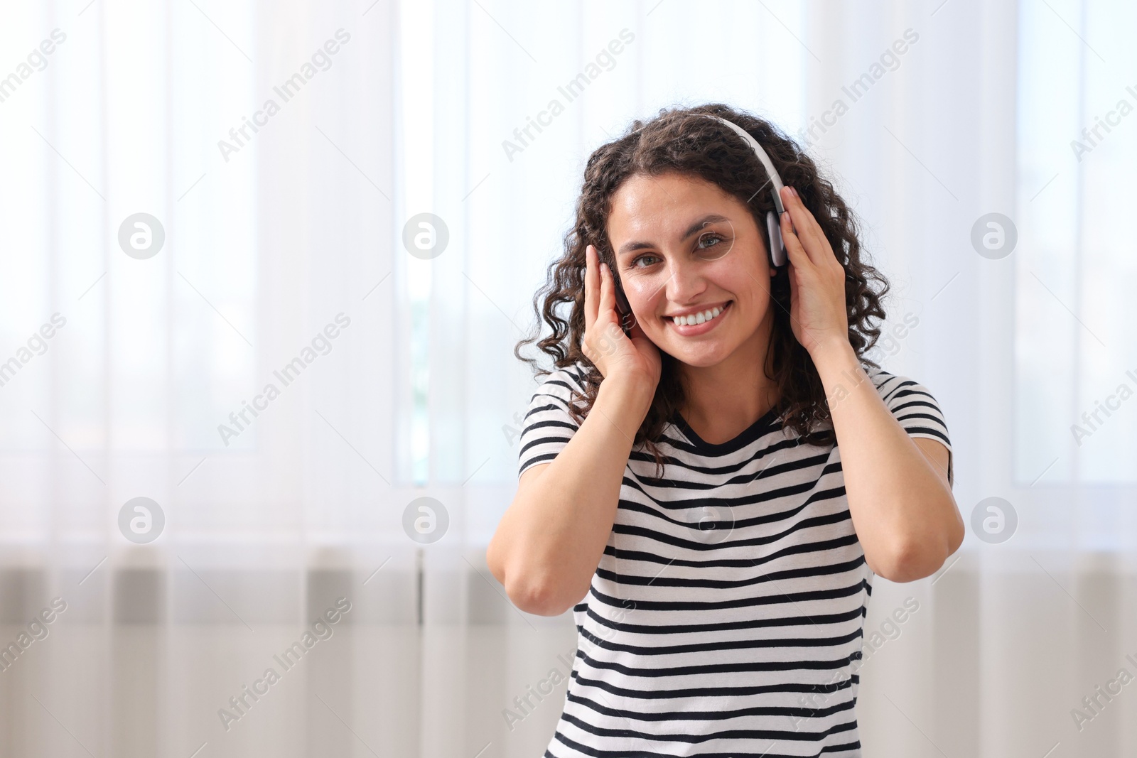 Photo of Young woman with headphones listening to music at home