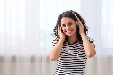 Photo of Young woman with headphones listening to music at home
