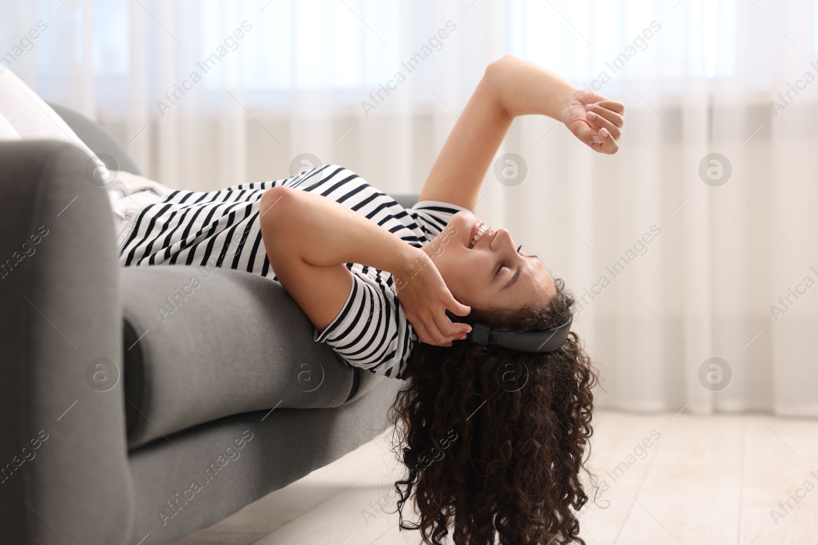 Photo of Young woman with headphones listening to music at home