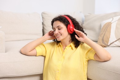 Photo of Young woman with headphones listening to music at home