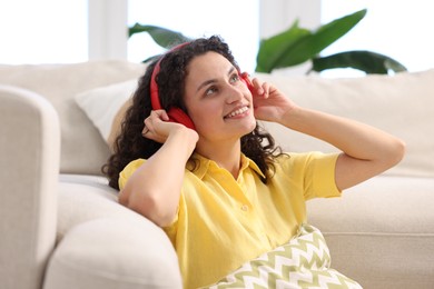 Photo of Young woman with headphones listening to music at home