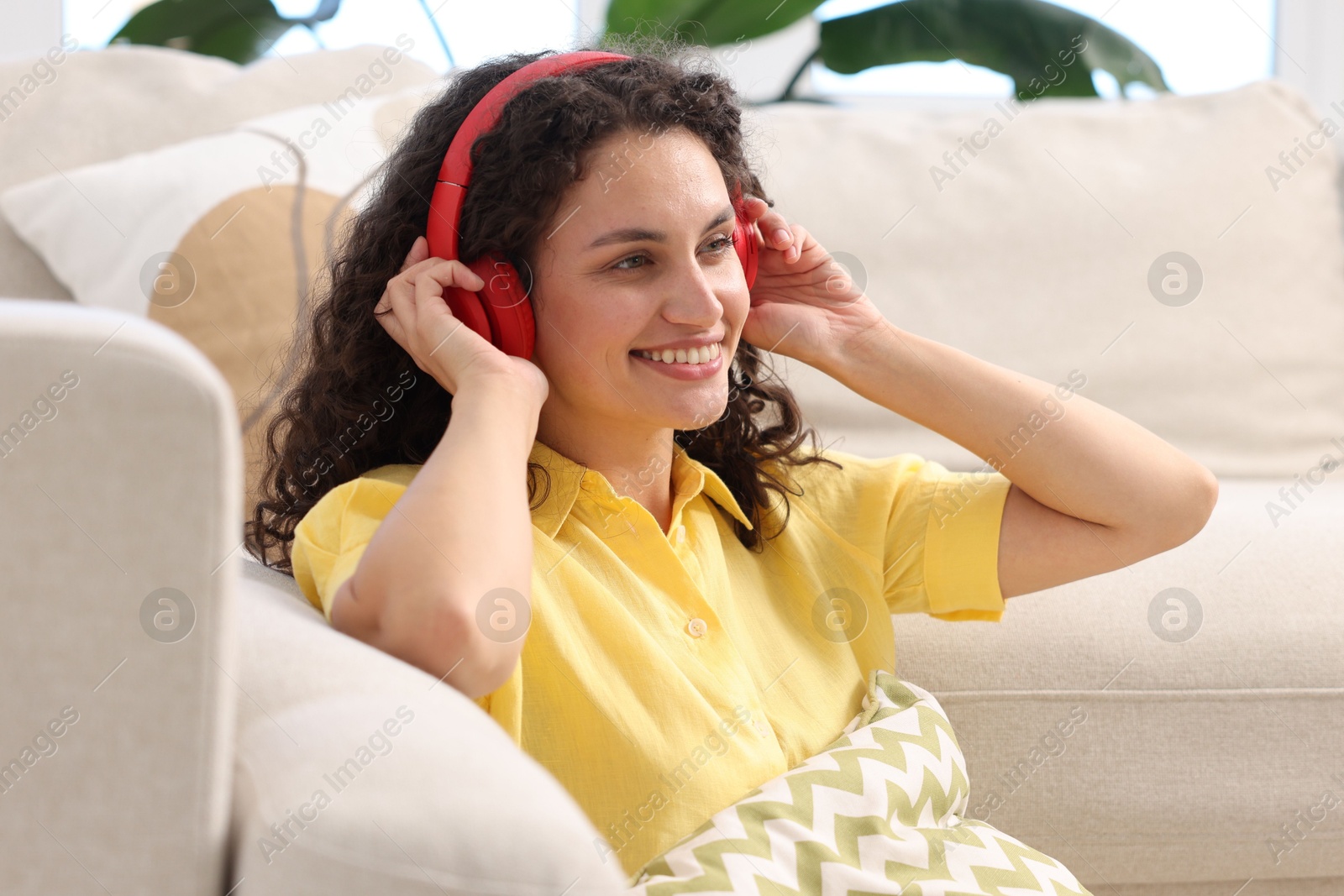 Photo of Young woman with headphones listening to music at home