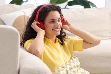 Photo of Young woman with headphones listening to music at home