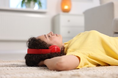 Photo of Young woman with headphones listening to music at home