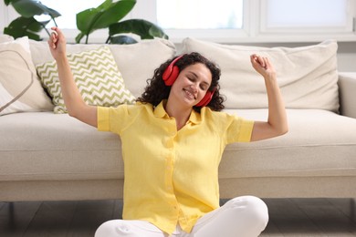 Photo of Young woman with headphones listening to music at home