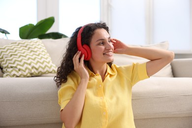 Photo of Young woman with headphones listening to music at home
