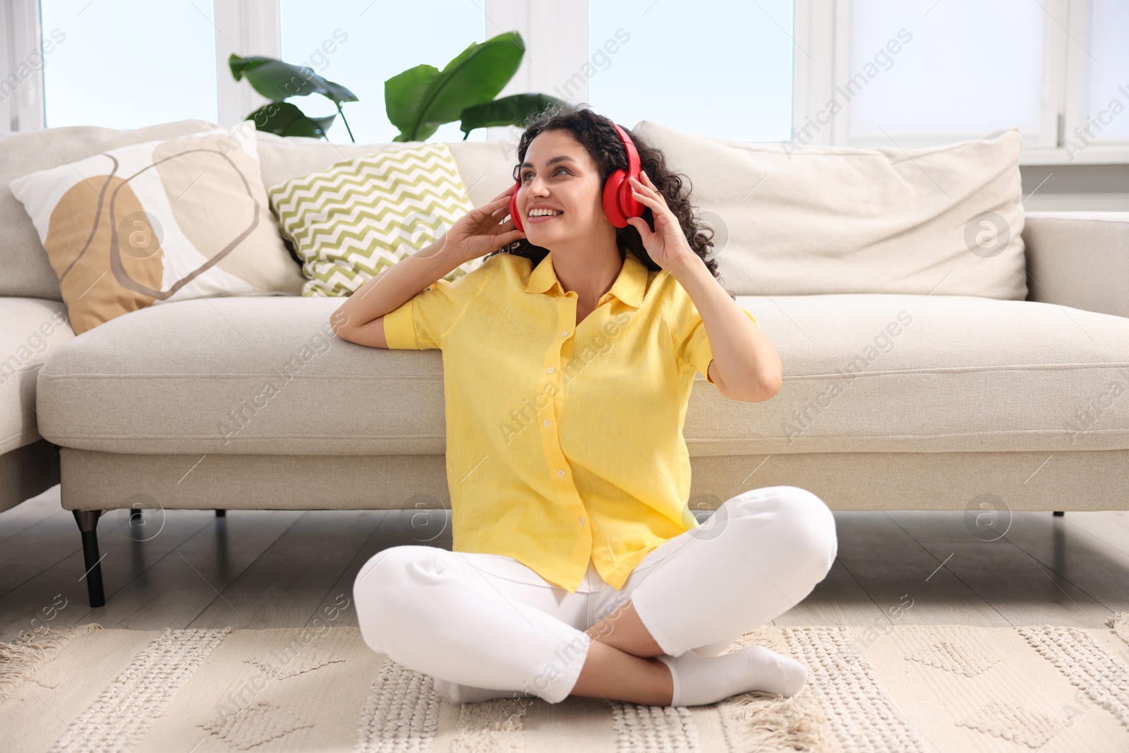 Photo of Young woman with headphones listening to music at home