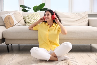 Photo of Young woman with headphones listening to music at home
