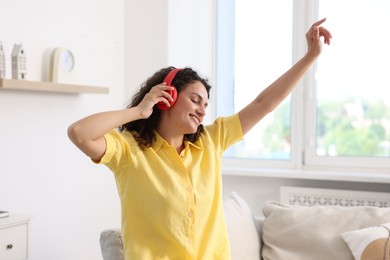 Photo of Young woman with headphones listening to music at home