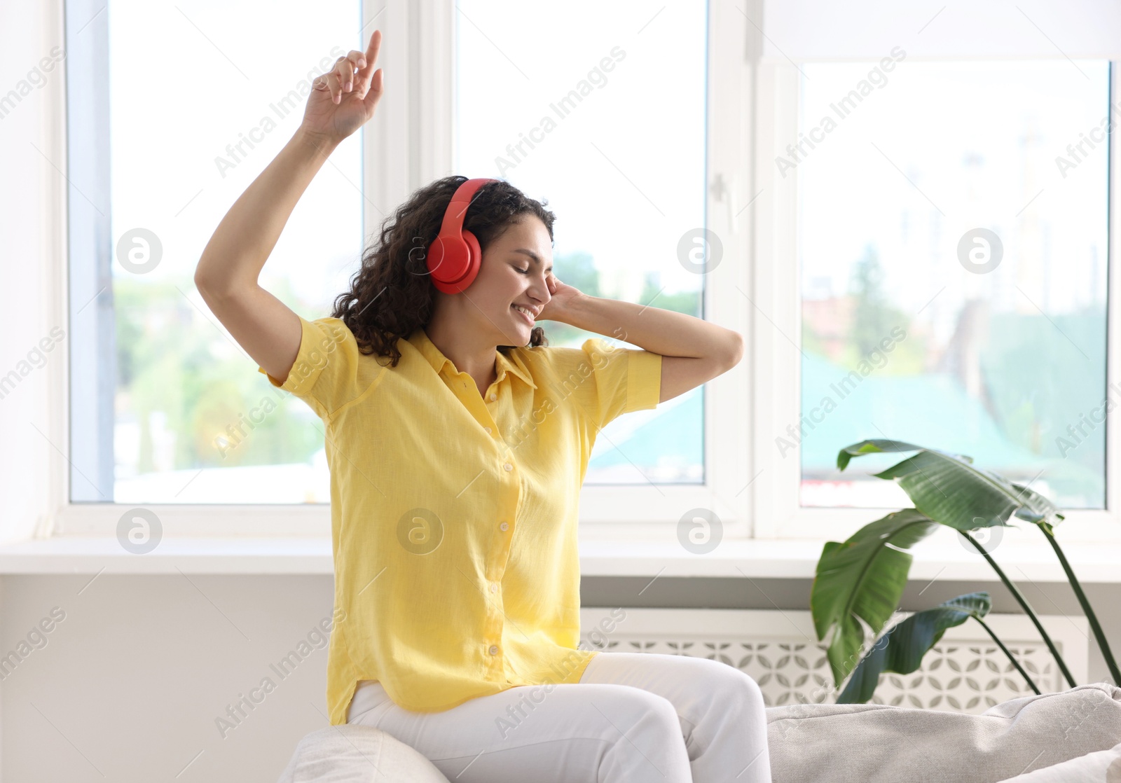 Photo of Young woman with headphones listening to music at home