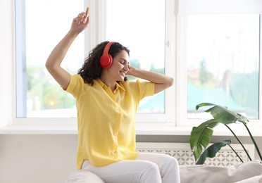 Photo of Young woman with headphones listening to music at home