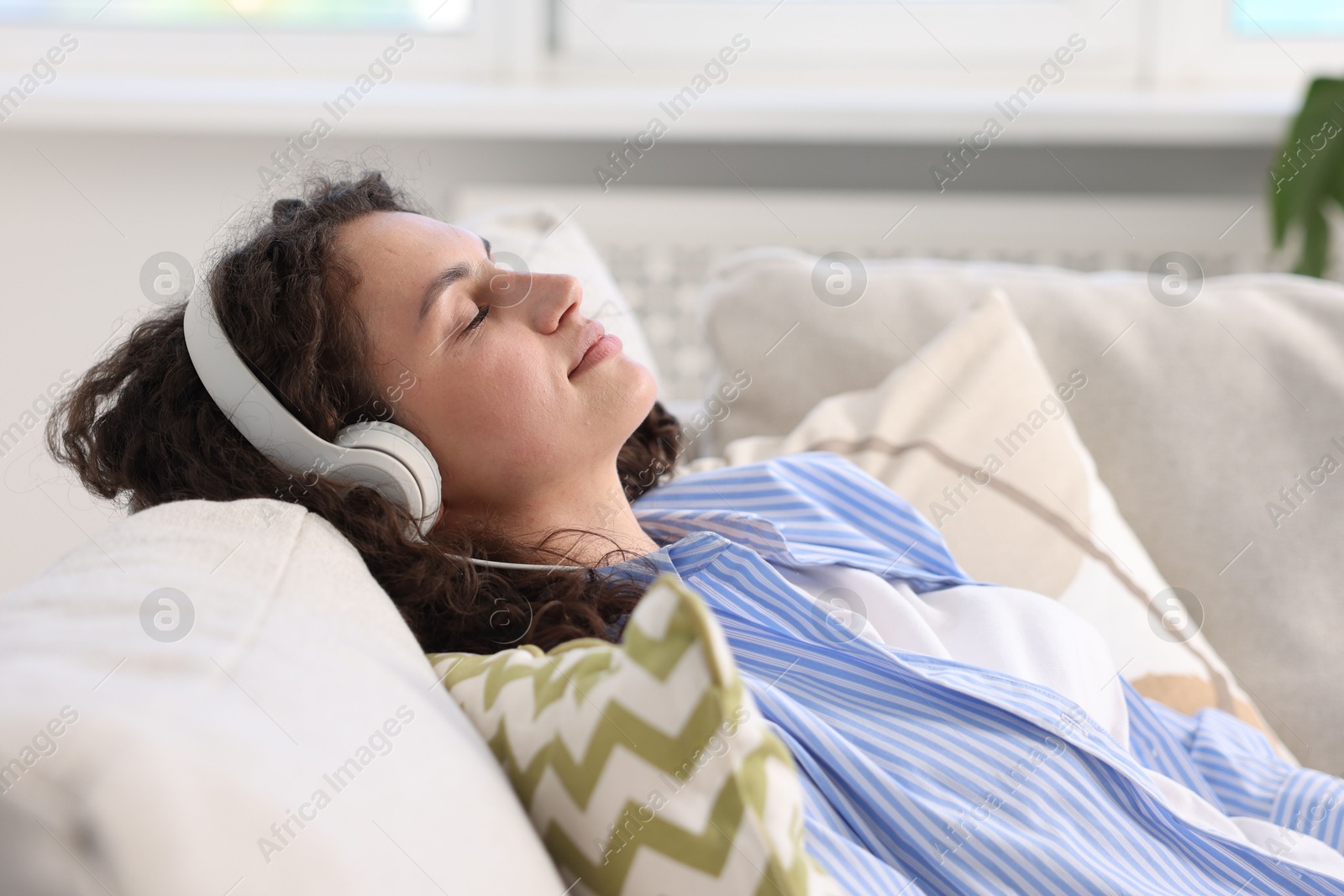 Photo of Young woman with headphones listening to music at home