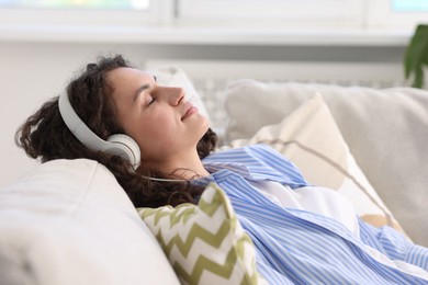 Photo of Young woman with headphones listening to music at home
