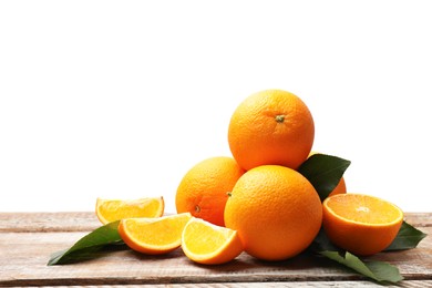 Photo of Pile of juicy oranges and green leaves on wooden table against white background