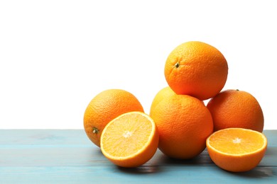 Photo of Pile of juicy oranges on light blue wooden table against white background. Space for text