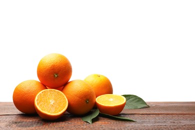 Photo of Pile of juicy oranges and green leaves on wooden table against white background. Space for text