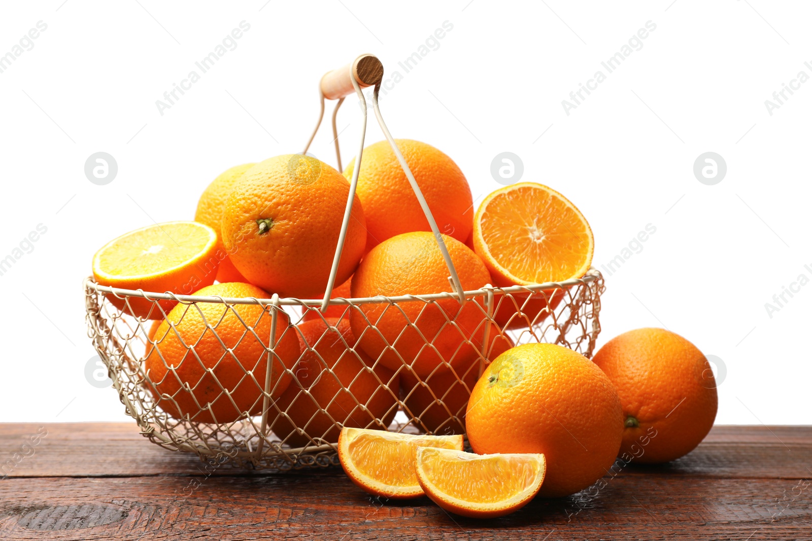 Photo of Juicy oranges and metal basket on wooden table against white background