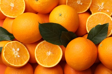 Photo of Juicy oranges and green leaves as background, top view