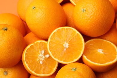 Photo of Fresh cut and whole oranges as background, top view