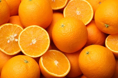 Photo of Fresh cut and whole oranges as background, top view