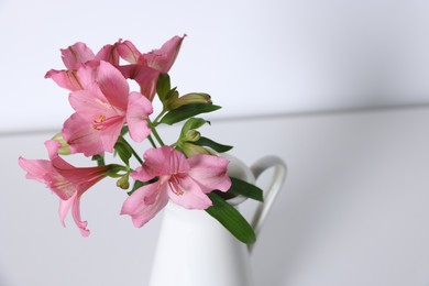 Photo of Beautiful flowers in vase on white table, closeup. Space for text