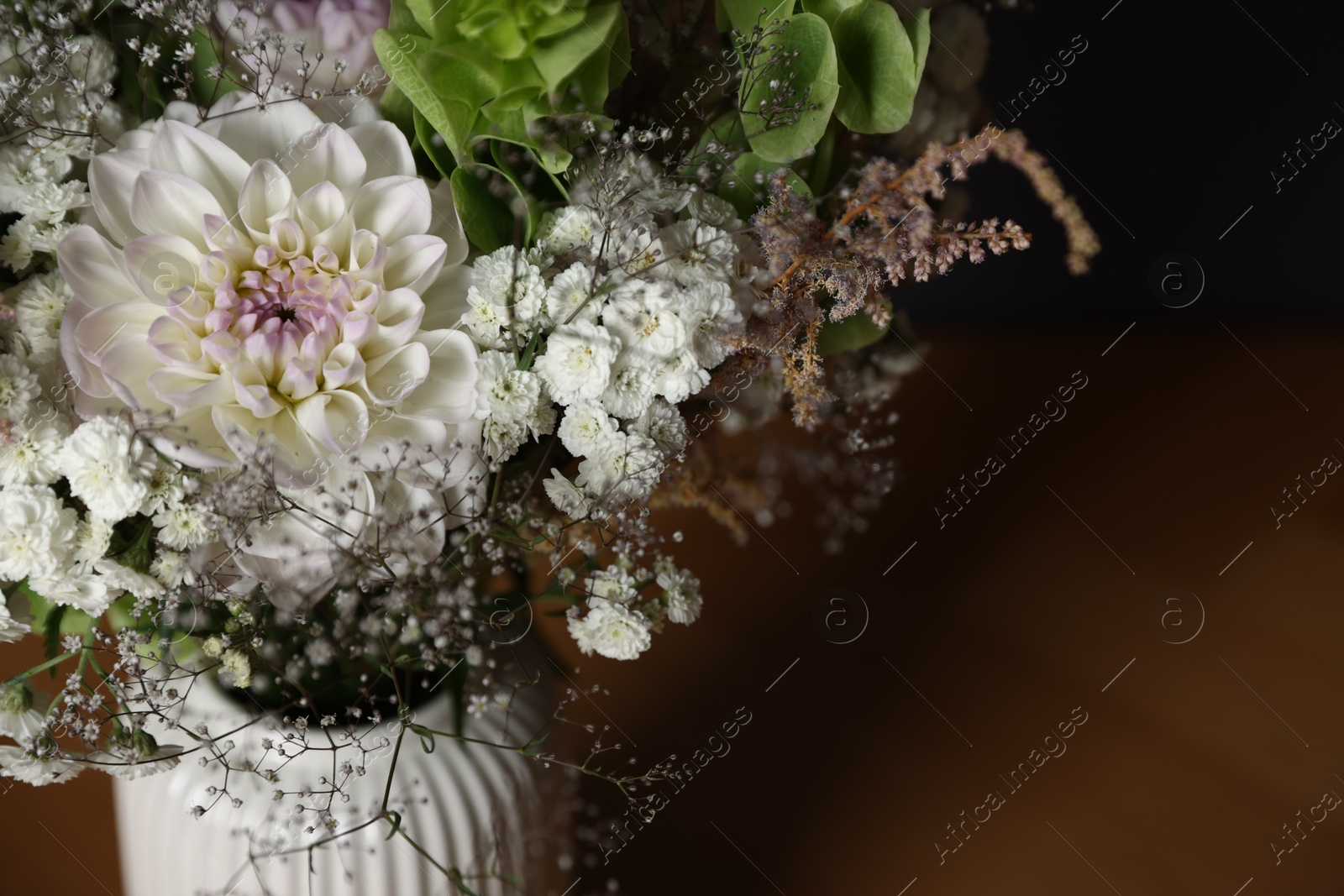 Beautiful flowers in vase on wooden table, closeup. Space for text Photo of Beautiful flowers in vase on wooden table, closeup. Space for text