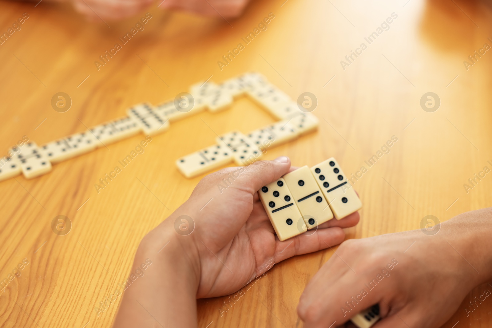 Man playing dominoes at wooden table, closeup Photo of Man playing dominoes at wooden table, closeup