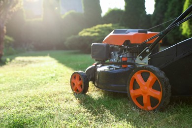 Photo of One lawn mower on green grass in garden, closeup. Space for text