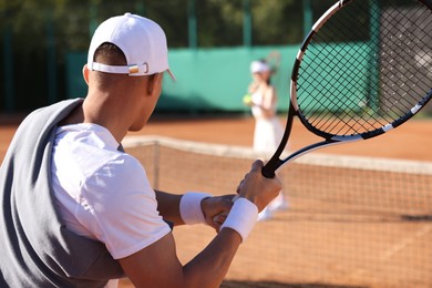 Photo of Man and woman playing tennis at court