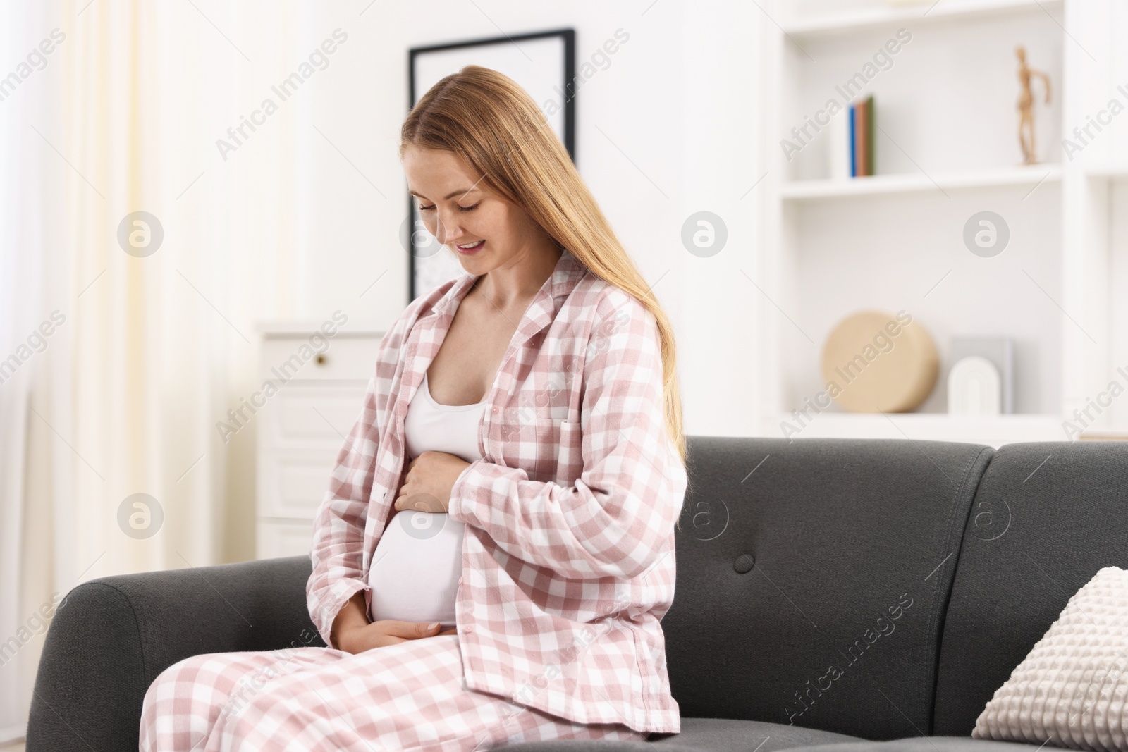 Beautiful pregnant woman on sofa at home Photo of Beautiful pregnant woman on sofa at home