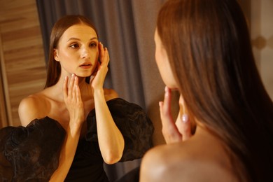 Photo of Beautiful woman getting ready near mirror indoors