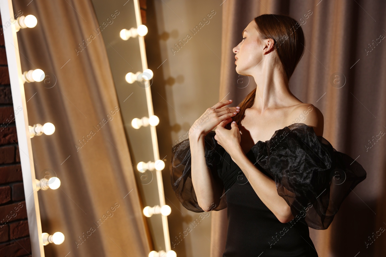 Beautiful woman getting ready near mirror indoors Photo of Beautiful woman getting ready near mirror indoors