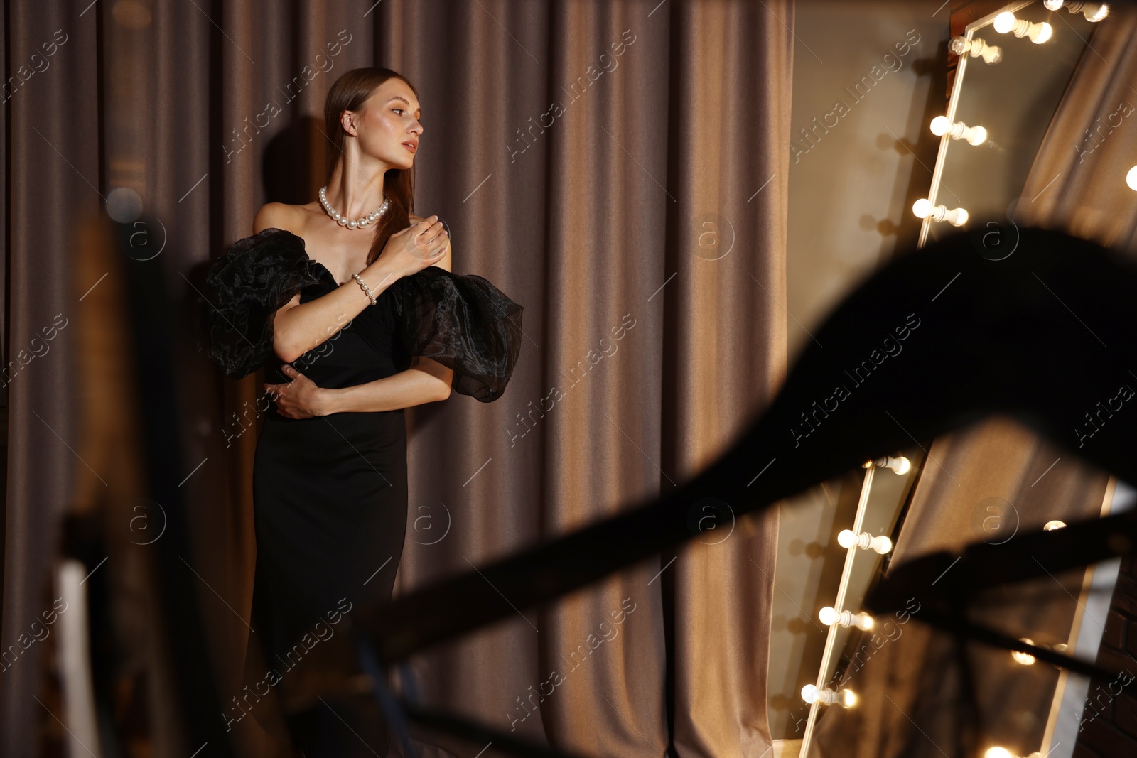 Beautiful woman getting ready near mirror indoors Photo of Beautiful woman getting ready near mirror indoors
