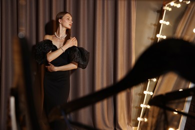 Photo of Beautiful woman getting ready near mirror indoors