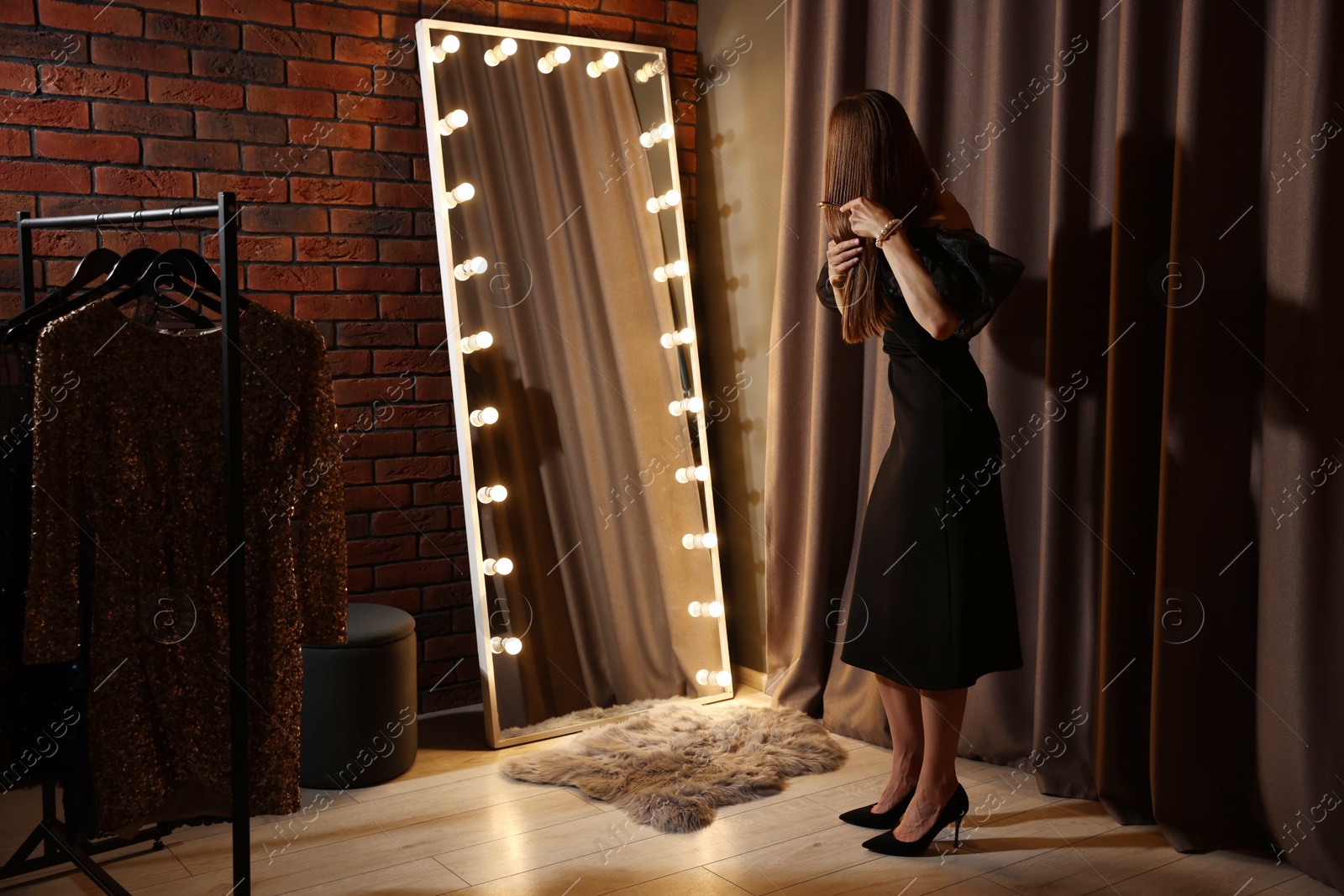Woman brushing her hair while getting ready near mirror indoors Photo of Woman brushing her hair while getting ready near mirror indoors