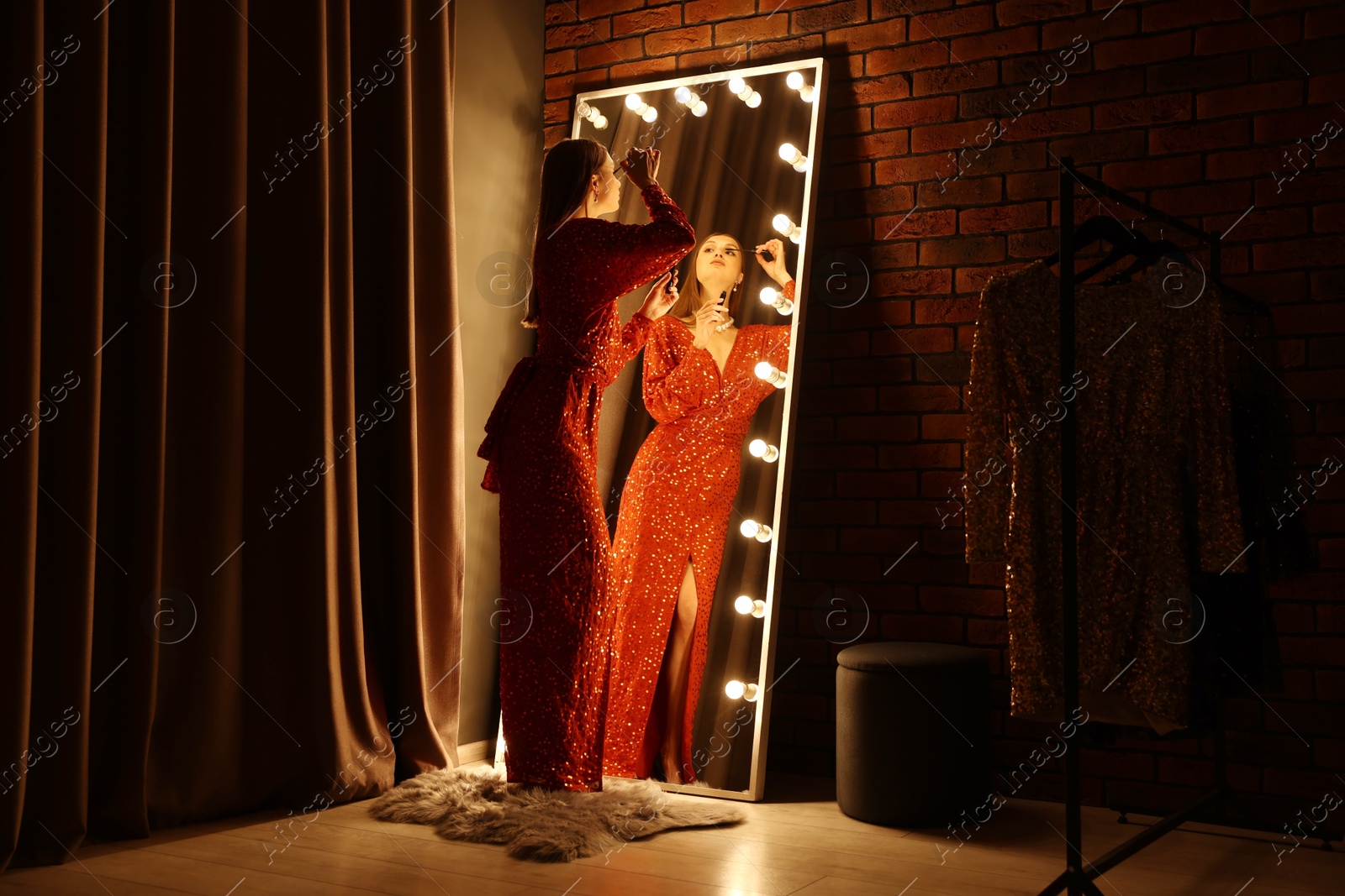Beautiful woman applying mascara while getting ready near mirror indoors Photo of Beautiful woman applying mascara while getting ready near mirror indoors