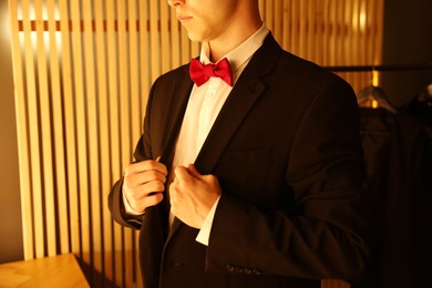 Photo of Man with bow tie getting ready indoors, closeup